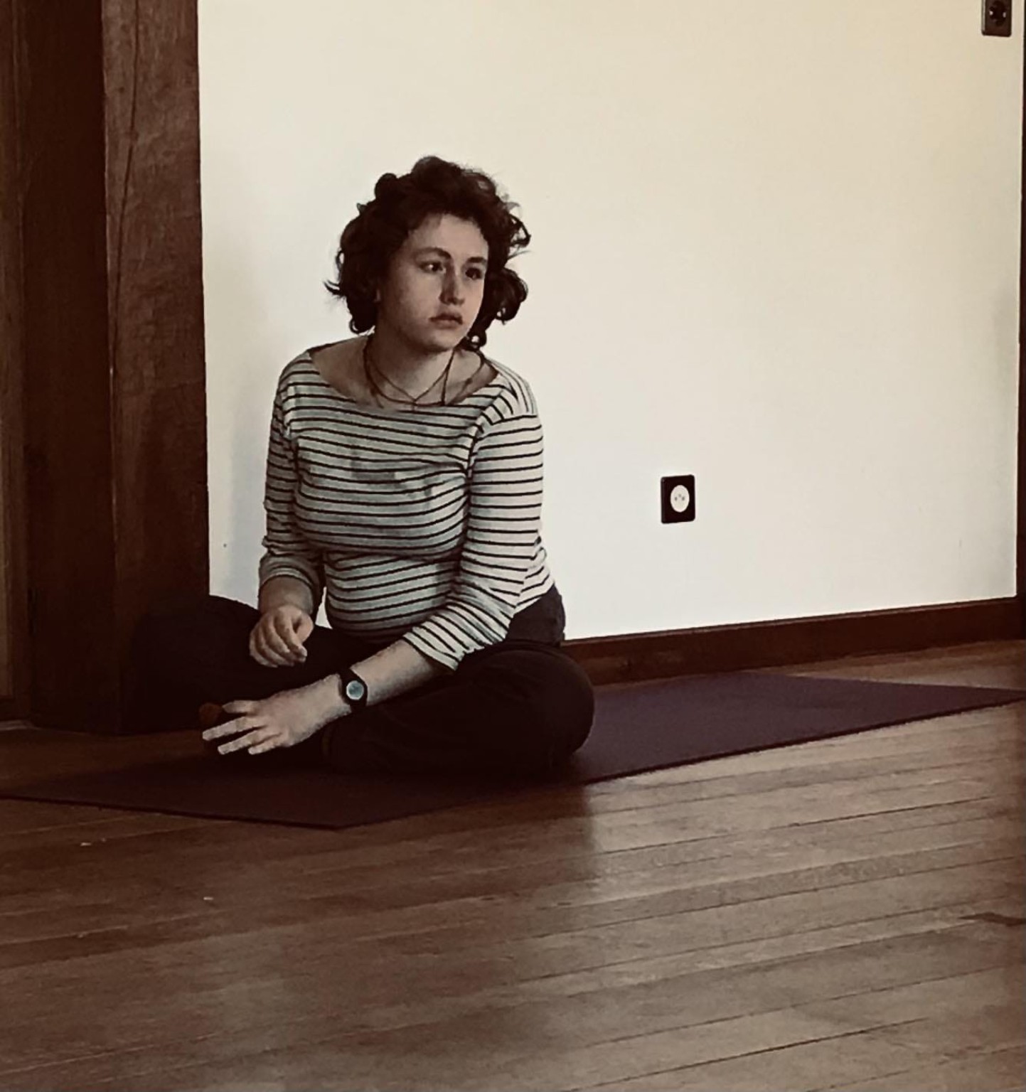 Lou assise sur un tapis de yoga